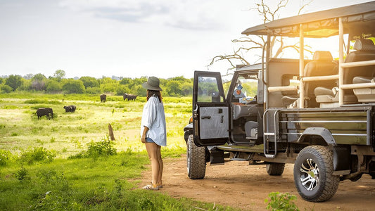 A safari vehicle with tourists observing wildlife in a grassy field at Udawalawe National Park.