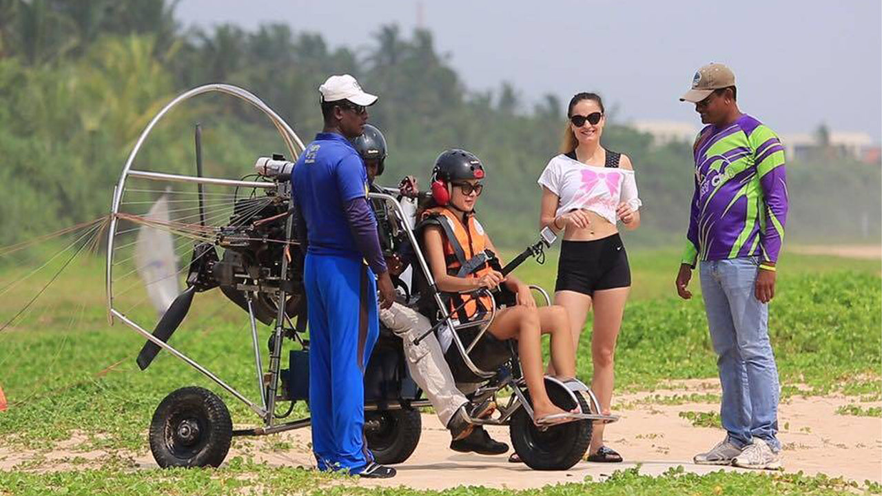 People with a paramotor on a grassy field