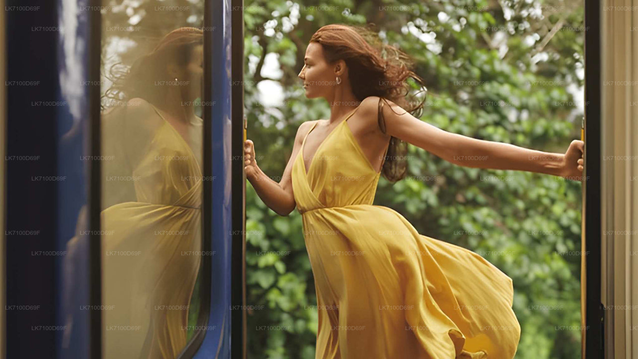 Woman in a yellow dress standing in front of a glass door with greenery outside.