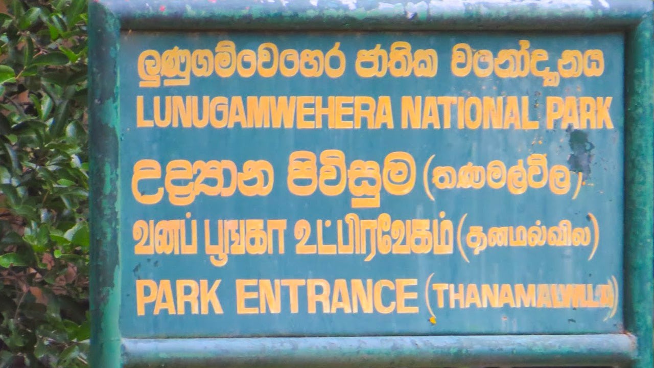 Signboard for Lunugamvehera National Park entrance with text in Sinhala and English.