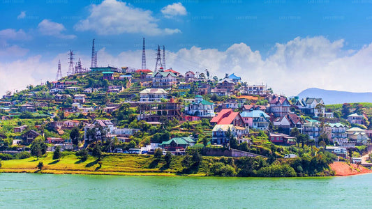 A scenic view of Nuwara Eliya city with its colonial architecture, tea plantations, and a body of water in the foreground.
